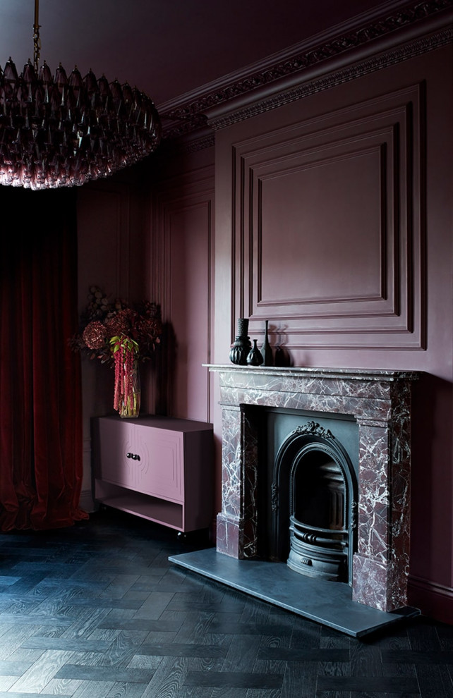 Идея дизайна: гостиная комната в викторианском стиле с красными стенами, темным паркетным полом, фасадом камина из камня, черным полом и панелями на части стены