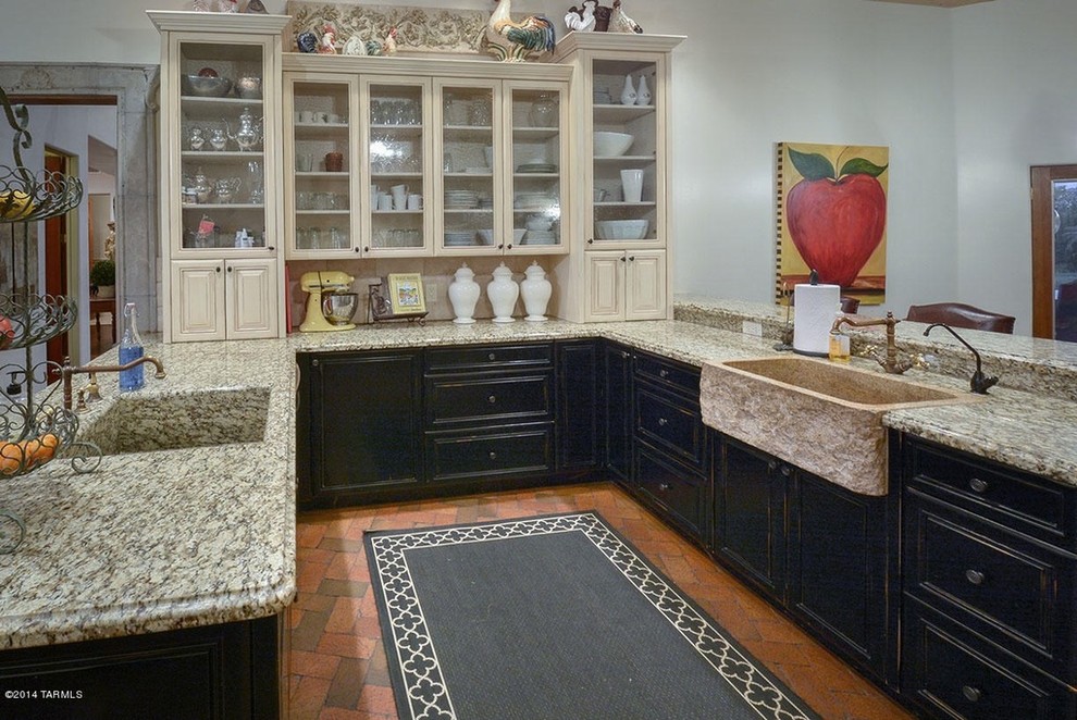 This is an example of a large country u-shaped eat-in kitchen in Phoenix with a farmhouse sink, recessed-panel cabinets, black cabinets, granite benchtops, brick floors and no island.