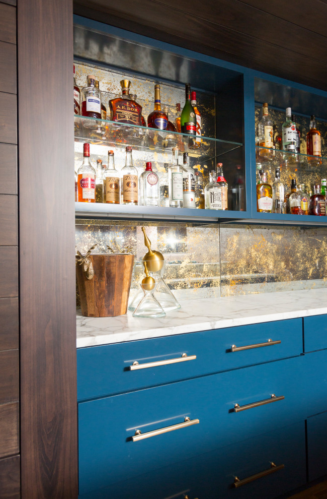Immagine di un angolo bar con lavandino classico di medie dimensioni con ante lisce, ante blu, top in marmo, paraspruzzi multicolore, paraspruzzi a specchio, pavimento in legno massello medio, pavimento marrone e top bianco