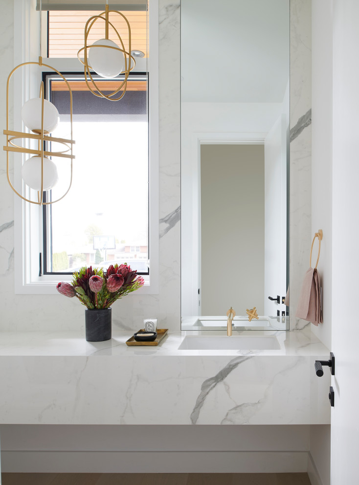 Photo of a medium sized contemporary bathroom in Toronto with white cabinets, a wall mounted toilet, grey tiles, stone slabs, white walls, light hardwood flooring, a submerged sink, tiled worktops, beige floors, white worktops and a floating vanity unit.