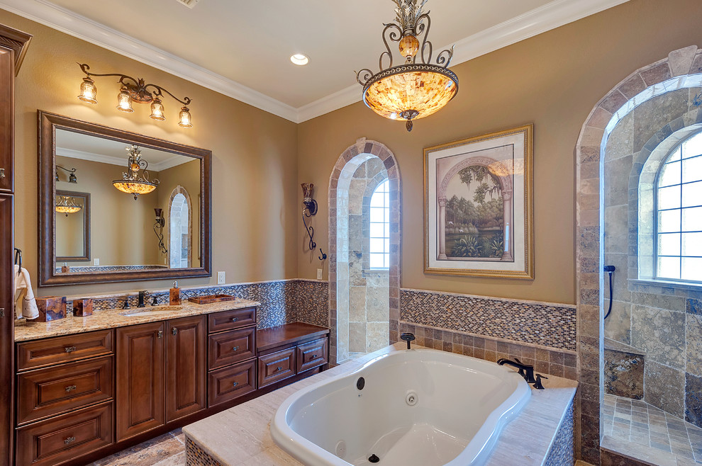 Expansive traditional master bathroom in Miami with an undermount sink, raised-panel cabinets, medium wood cabinets, granite benchtops, a drop-in tub, a double shower, multi-coloured tile, mosaic tile and beige walls.