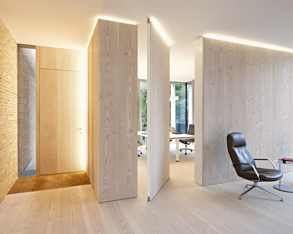 Inspiration for a contemporary entryway in Hamburg with light hardwood floors, a single front door, a light wood front door and beige walls.