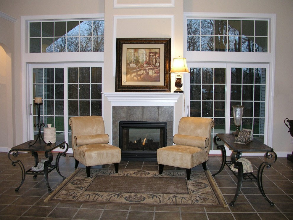 Photo of a mid-sized traditional formal living room in Other with beige walls, ceramic floors, a standard fireplace, a tile fireplace surround and brown floor.