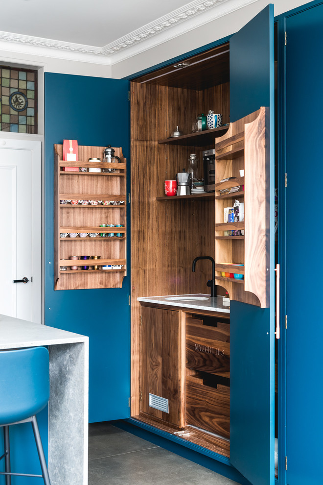 Photo of a contemporary kitchen pantry in London with an undermount sink, blue cabinets and grey floor.