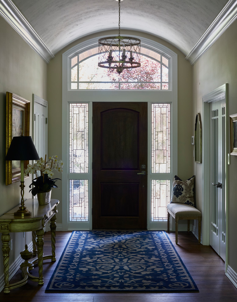 Design ideas for a traditional foyer in Grand Rapids with black walls, dark hardwood floors, a single front door and a dark wood front door.