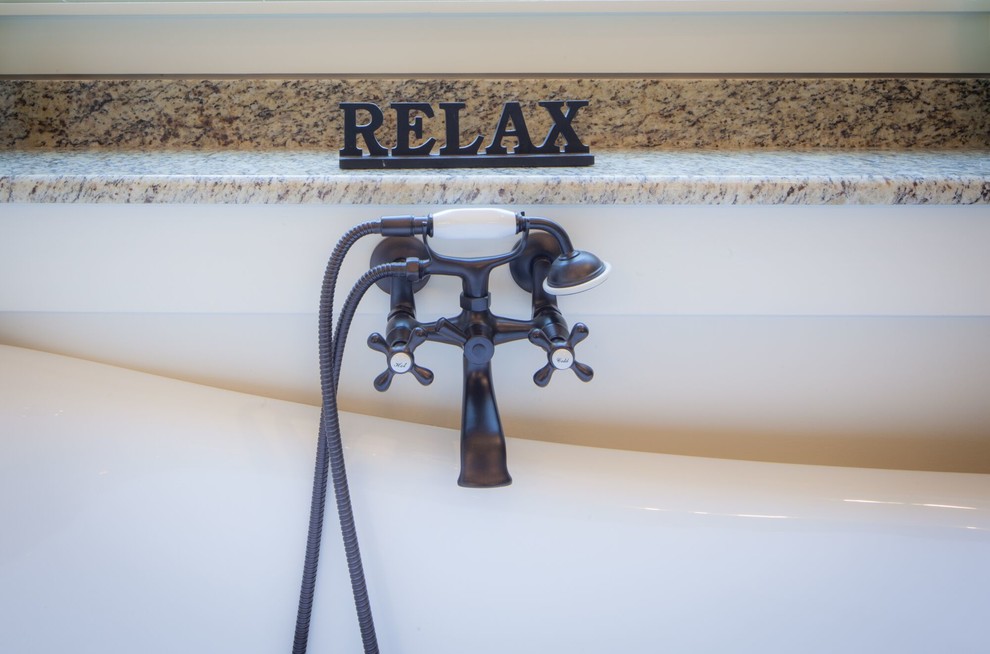 Example of a mid-sized transitional master beige tile and stone tile ceramic tile and beige floor freestanding bathtub design with raised-panel cabinets, gray cabinets, beige walls, an undermount sink, granite countertops and a hinged shower door