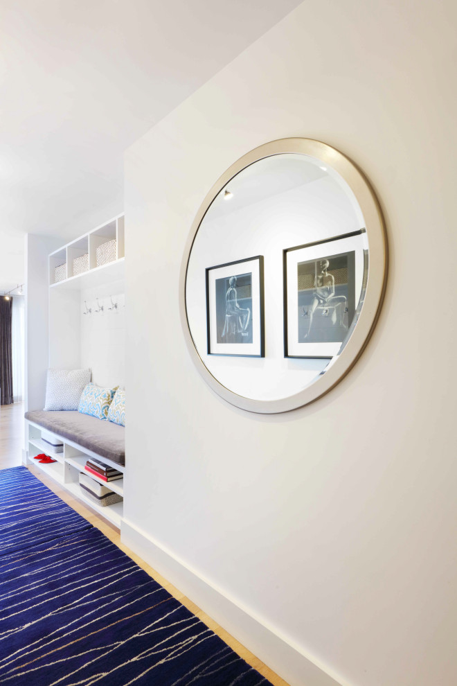 Example of a small transitional light wood floor and beige floor entry hall design with white walls