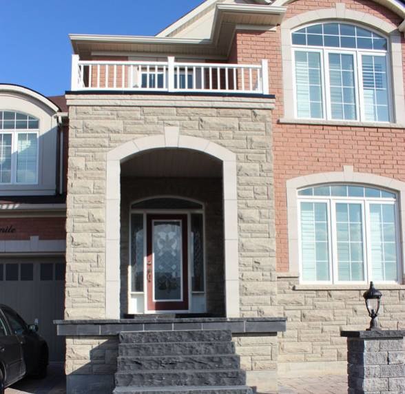 Photo of a large traditional full sun front yard stone driveway in Toronto.