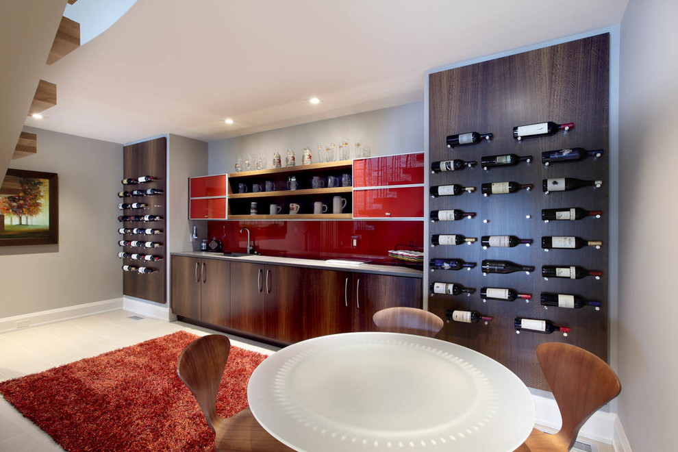 Photo of a large contemporary single-wall home bar in Grand Rapids with an undermount sink, flat-panel cabinets, dark wood cabinets, red splashback and glass sheet splashback.