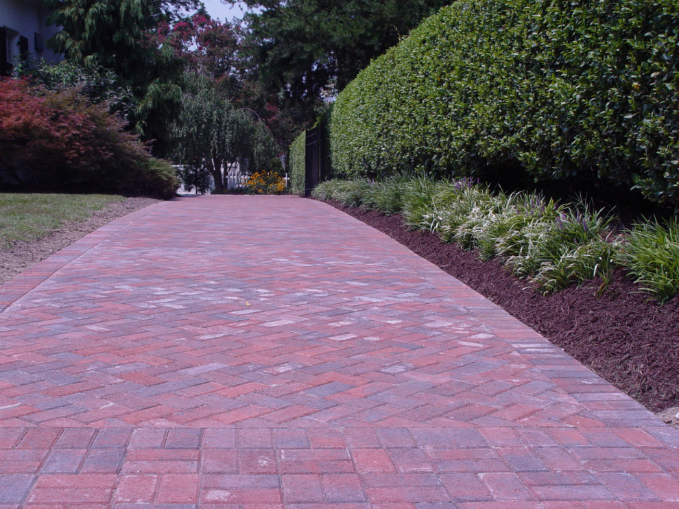 This is an example of a large traditional front yard partial sun driveway in Richmond with brick pavers.