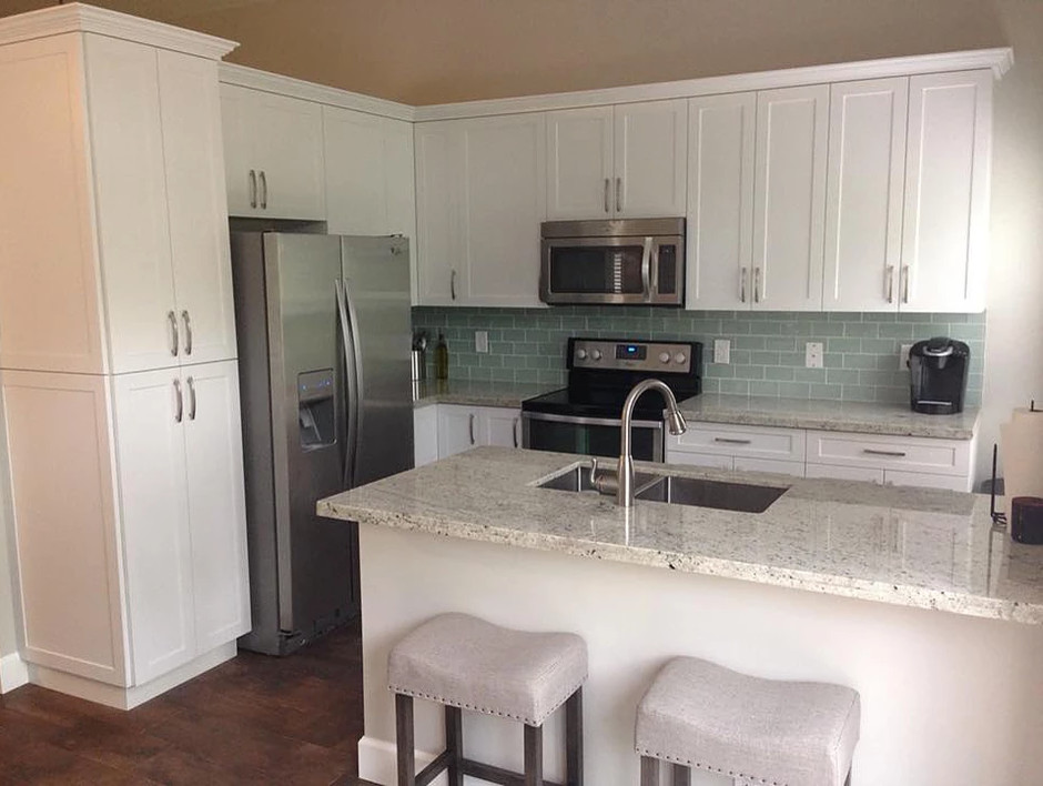 Open concept kitchen - mid-sized transitional l-shaped dark wood floor and brown floor open concept kitchen idea in Miami with a double-bowl sink, shaker cabinets, white cabinets, granite countertops, blue backsplash, glass tile backsplash, stainless steel appliances and an island