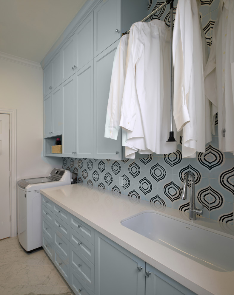 Design ideas for a mid-sized contemporary galley dedicated laundry room in Houston with an undermount sink, shaker cabinets, blue cabinets, quartz benchtops, white walls, porcelain floors, a side-by-side washer and dryer, grey floor and white benchtop.