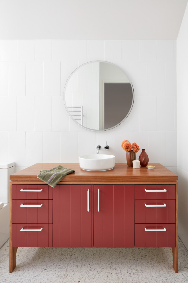 Large contemporary master bathroom in Melbourne with red cabinets, a two-piece toilet, white tile, white walls, terrazzo floors, wood benchtops, brown benchtops, a single vanity, a freestanding vanity, flat-panel cabinets, a vessel sink, grey floor and vaulted.