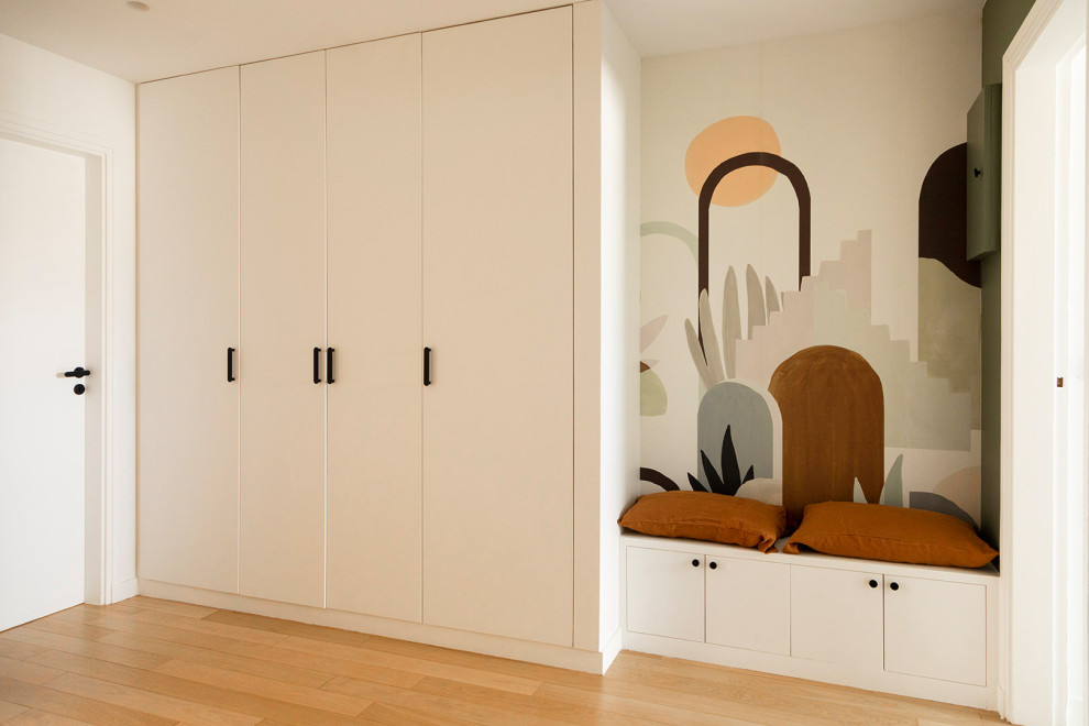 Example of a mid-sized light wood floor, beige floor and wallpaper hallway design in Paris with multicolored walls