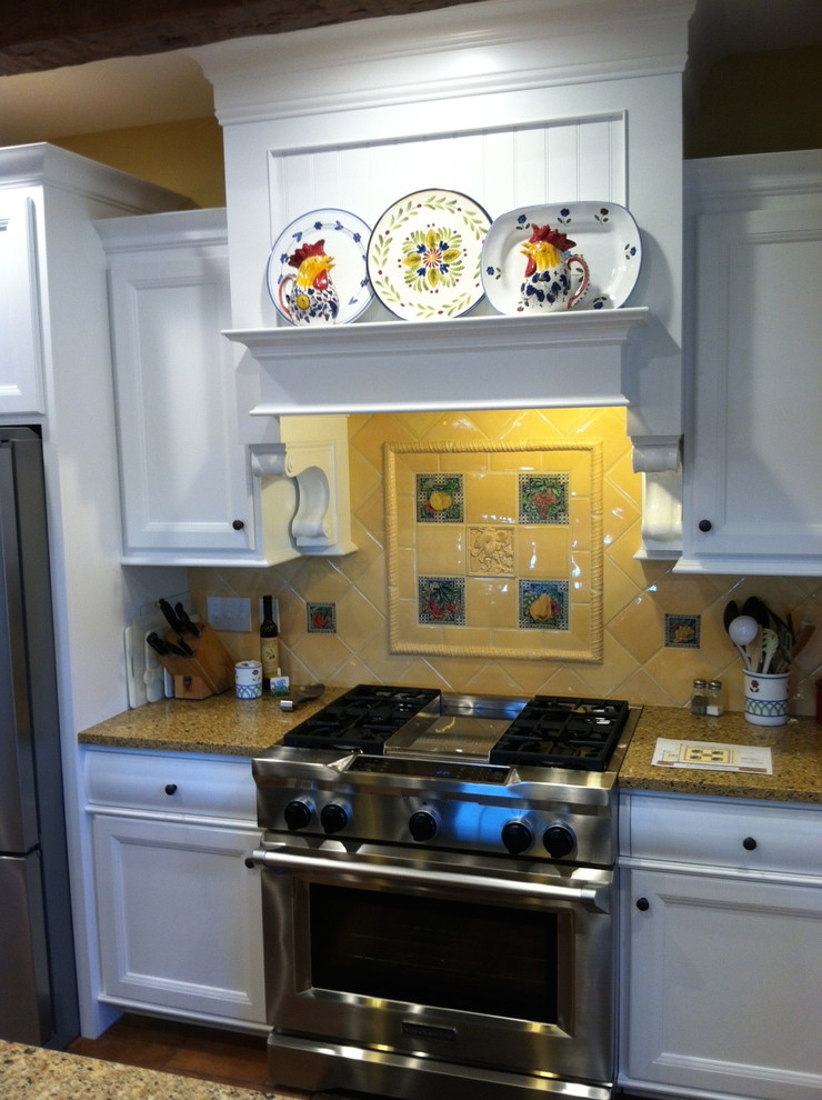 Example of a classic kitchen design with recessed-panel cabinets, white cabinets, granite countertops, yellow backsplash and ceramic backsplash