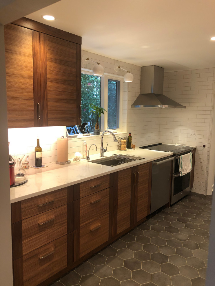 This is an example of a mid-sized transitional galley eat-in kitchen in Seattle with an undermount sink, flat-panel cabinets, medium wood cabinets, quartz benchtops, white splashback, subway tile splashback, stainless steel appliances, ceramic floors, no island, grey floor and white benchtop.