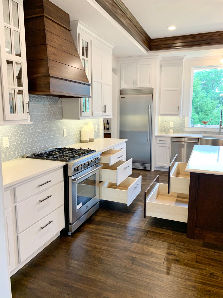 Design ideas for a large transitional galley eat-in kitchen in Other with a farmhouse sink, recessed-panel cabinets, white cabinets, quartz benchtops, blue splashback, ceramic splashback, stainless steel appliances, medium hardwood floors, with island, brown floor, white benchtop and timber.