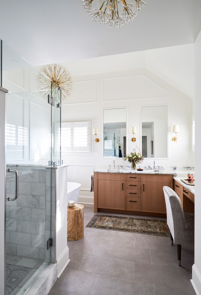 Inredning av ett modernt stort flerfärgad flerfärgat en-suite badrum, med släta luckor, skåp i ljust trä, ett fristående badkar, en dubbeldusch, flerfärgad kakel, marmorkakel, ett nedsänkt handfat, marmorbänkskiva, dusch med gångjärnsdörr, en toalettstol med hel cisternkåpa, vita väggar, klinkergolv i porslin och grått golv