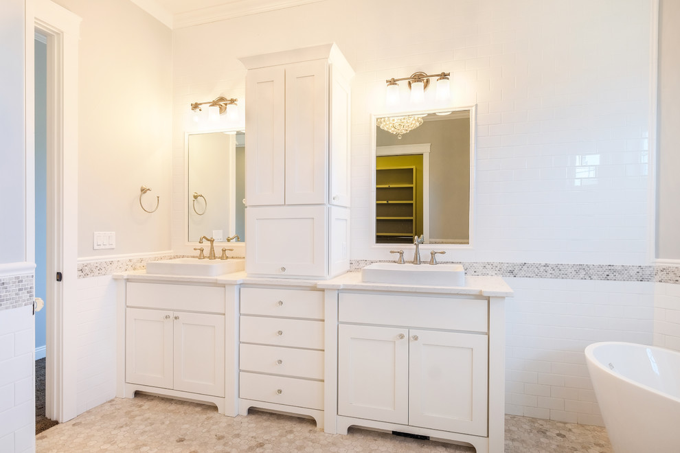 Large country master bathroom in Denver with shaker cabinets, white cabinets, a freestanding tub, a corner shower, a two-piece toilet, multi-coloured tile, white tile, subway tile, beige walls, porcelain floors, a trough sink and quartzite benchtops.