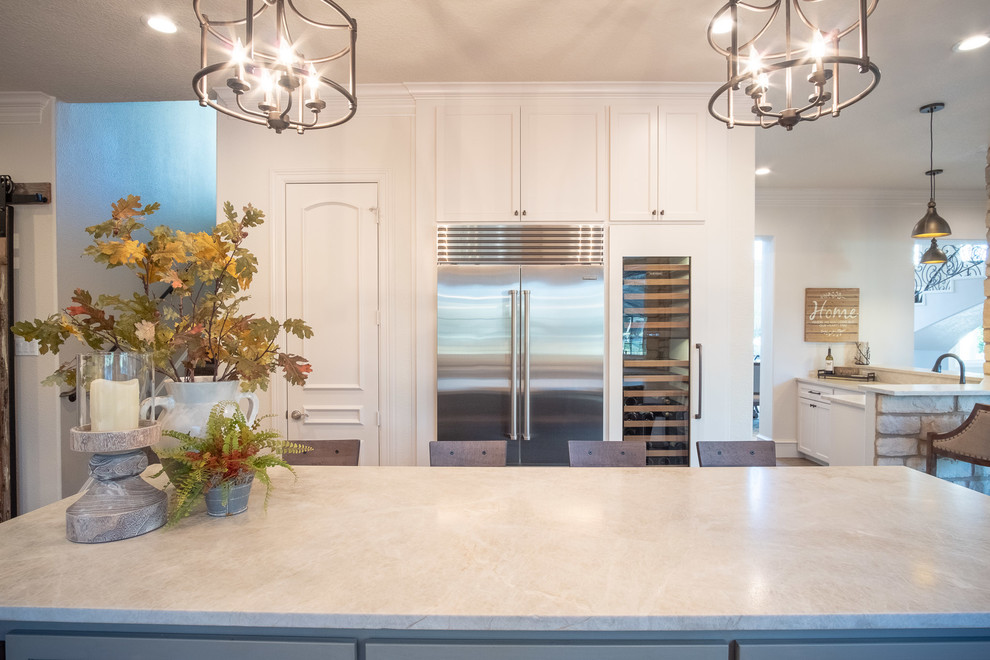 Inspiration for a large galley eat-in kitchen in Houston with a farmhouse sink, shaker cabinets, white cabinets, quartzite benchtops, multi-coloured splashback, stone tile splashback, stainless steel appliances, porcelain floors, with island, brown floor and multi-coloured benchtop.