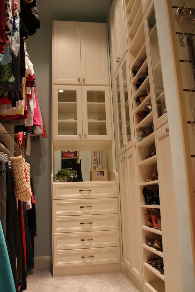 Photo of a large modern women's walk-in wardrobe in Dallas with white cabinets, linoleum floors and recessed-panel cabinets.