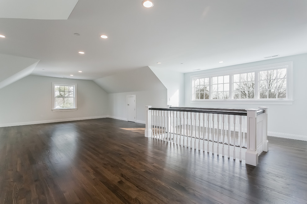 Photo of a large transitional gender-neutral kids' playroom in New York with dark hardwood floors and grey walls.