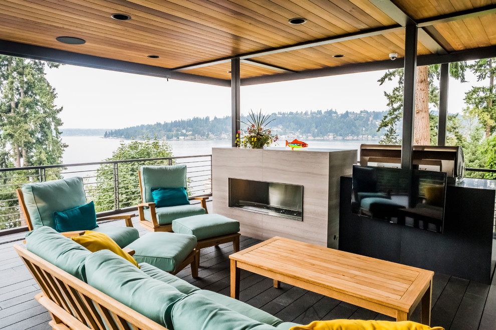 Large midcentury deck in Seattle with a fire feature and a roof extension.