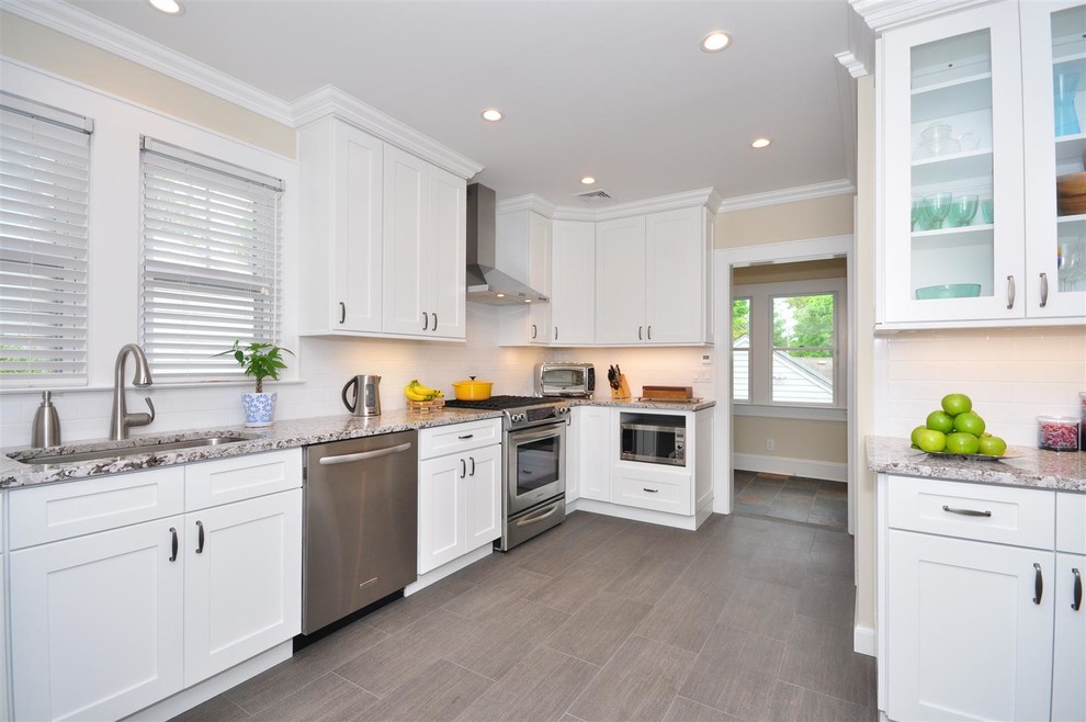 This is an example of a traditional kitchen in New York with an undermount sink, shaker cabinets, white cabinets, white splashback, subway tile splashback and stainless steel appliances.