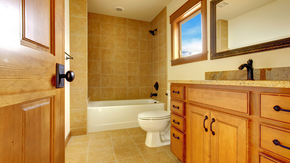 Inspiration for a mid-sized traditional kids bathroom in Other with raised-panel cabinets, brown cabinets, an alcove tub, a shower/bathtub combo, a two-piece toilet, beige tile, porcelain tile, beige walls, porcelain floors, an undermount sink, granite benchtops, beige floor, a shower curtain and beige benchtops.