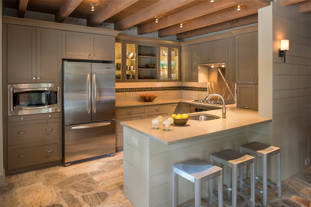 This is an example of a traditional u-shaped kitchen in Philadelphia with stainless steel appliances, concrete benchtops, shaker cabinets, grey cabinets, an undermount sink and multi-coloured splashback.