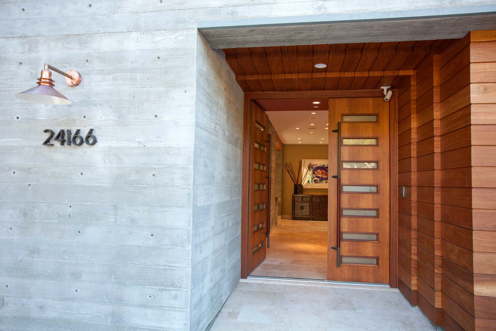 This is an example of an expansive beach style front door in Los Angeles with brown walls, slate floors, a double front door and a brown front door.