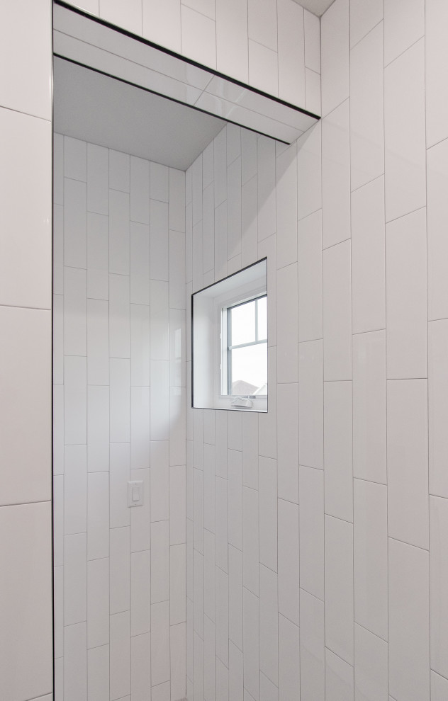 Foto på ett badrum, med vit kakel, tunnelbanekakel och mosaikgolv