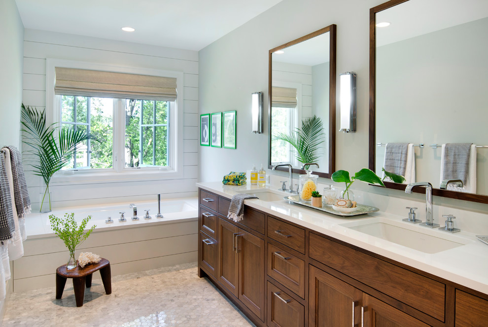 This is an example of a transitional bathroom in Minneapolis with recessed-panel cabinets, dark wood cabinets, an undermount tub, green walls, mosaic tile floors and an undermount sink.