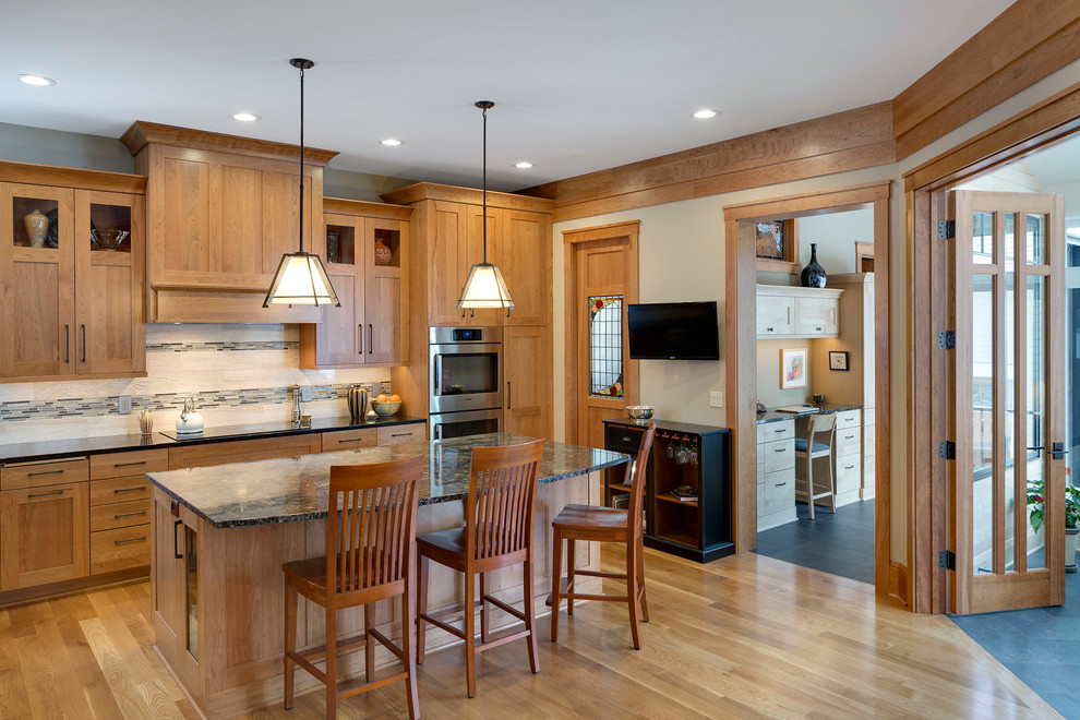 Inspiration for a large transitional l-shaped eat-in kitchen in Minneapolis with medium wood cabinets, granite benchtops, beige splashback, stainless steel appliances, medium hardwood floors, with island, recessed-panel cabinets, an undermount sink and matchstick tile splashback.