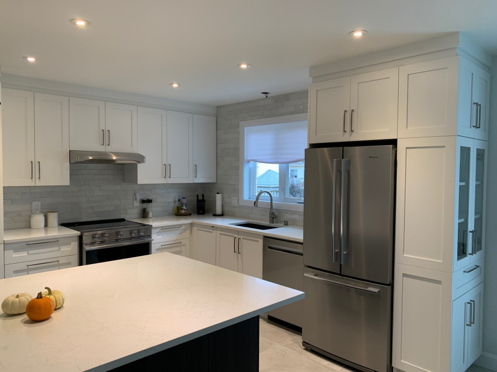 Mid-sized transitional l-shaped ceramic tile and gray floor eat-in kitchen photo in Montreal with an undermount sink, shaker cabinets, white cabinets, quartz countertops, gray backsplash, ceramic backsplash, stainless steel appliances, an island and white countertops