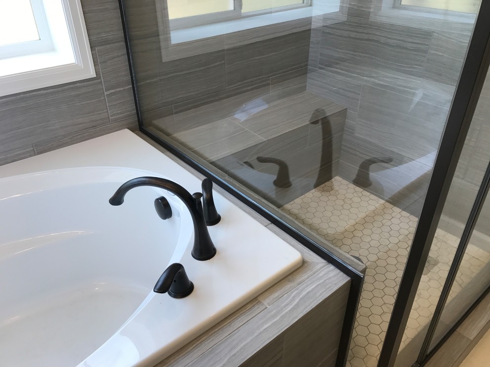 Drop-in bathtub - mid-sized transitional master gray tile drop-in bathtub idea in Denver with shaker cabinets, gray cabinets, gray walls, an undermount sink, granite countertops, a hinged shower door and white countertops