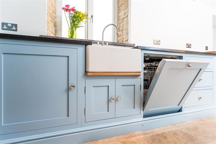 Small traditional u-shaped separate kitchen in Oxfordshire with a single-bowl sink, blue cabinets, granite benchtops, black splashback, black appliances, limestone floors and no island.