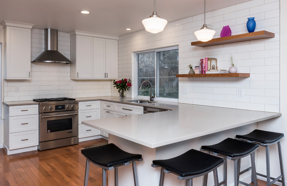 Mid-sized transitional u-shaped medium tone wood floor kitchen photo in Denver with an undermount sink, shaker cabinets, white cabinets, quartz countertops, white backsplash, subway tile backsplash, stainless steel appliances, a peninsula and beige countertops