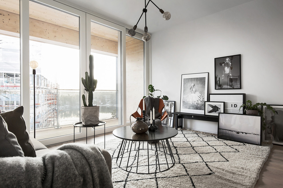 Inspiration for a mid-sized scandinavian living room in Stockholm with white walls, no tv, light hardwood floors and no fireplace.