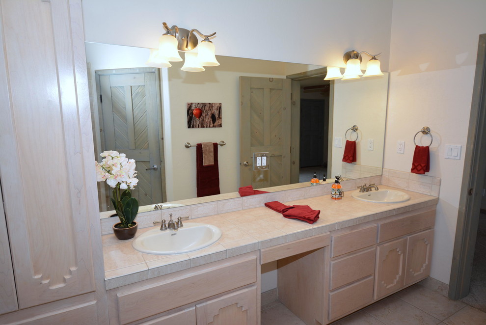 Inspiration for a mid-sized master bathroom in Albuquerque with a drop-in sink, raised-panel cabinets, light wood cabinets, tile benchtops, a corner shower, a two-piece toilet, beige tile, ceramic tile, white walls and ceramic floors.
