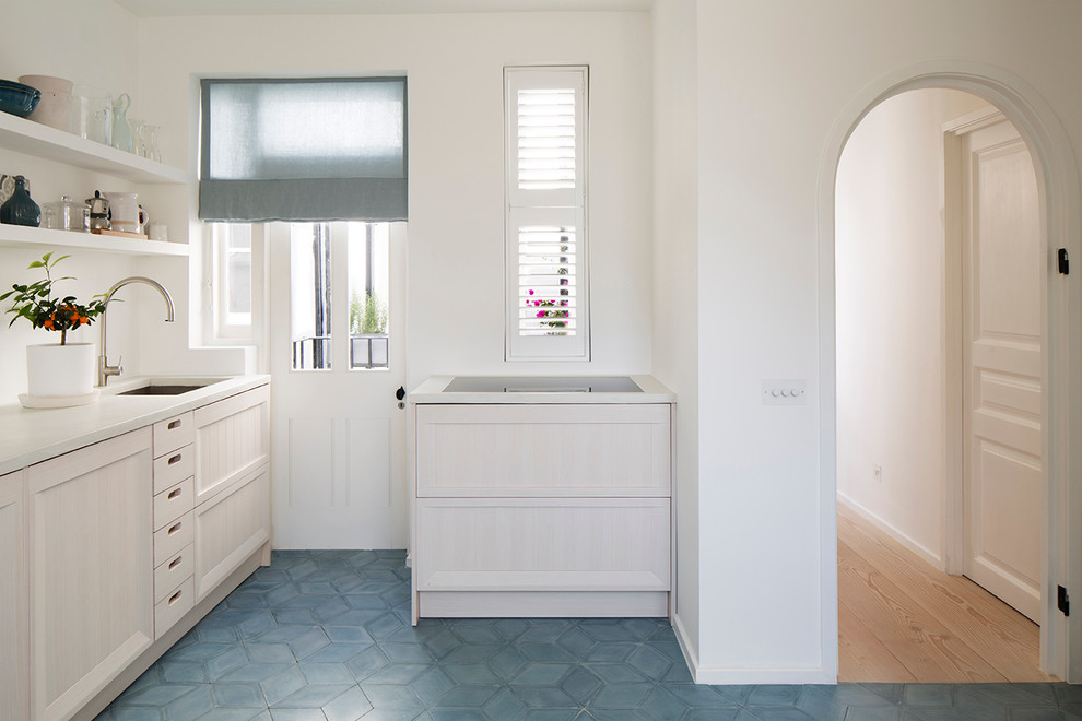 Photo of a medium sized contemporary galley kitchen/diner in London with a built-in sink, beaded cabinets, light wood cabinets, concrete worktops, white splashback, cement tile splashback, stainless steel appliances, cement flooring, no island and blue floors.