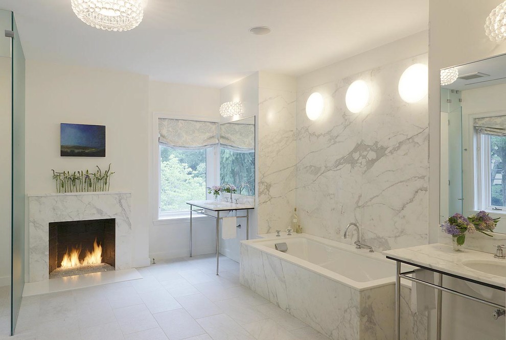 Contemporary bathroom in New York with a console sink, an undermount tub, white tile and stone slab.