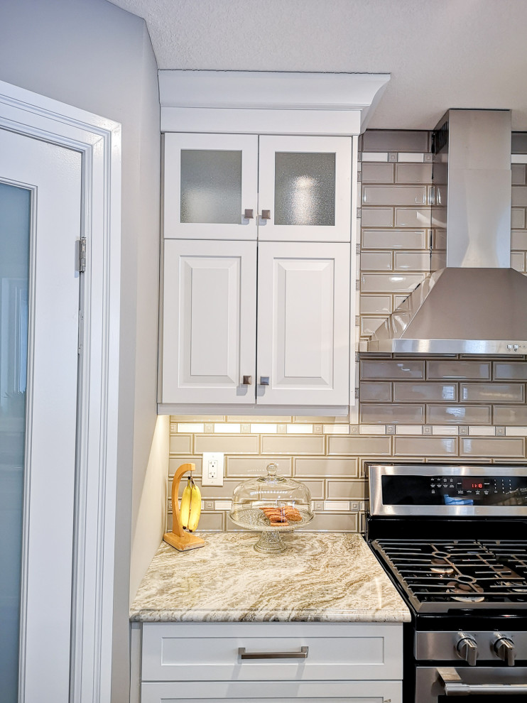 Enclosed kitchen - mid-sized transitional u-shaped light wood floor and brown floor enclosed kitchen idea in Toronto with an undermount sink, raised-panel cabinets, white cabinets, granite countertops, beige backsplash, glass tile backsplash, stainless steel appliances, a peninsula and gray countertops