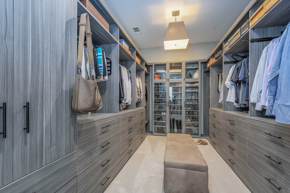 Large contemporary gender-neutral dressing room in San Francisco with flat-panel cabinets, carpet, beige floor and grey cabinets.