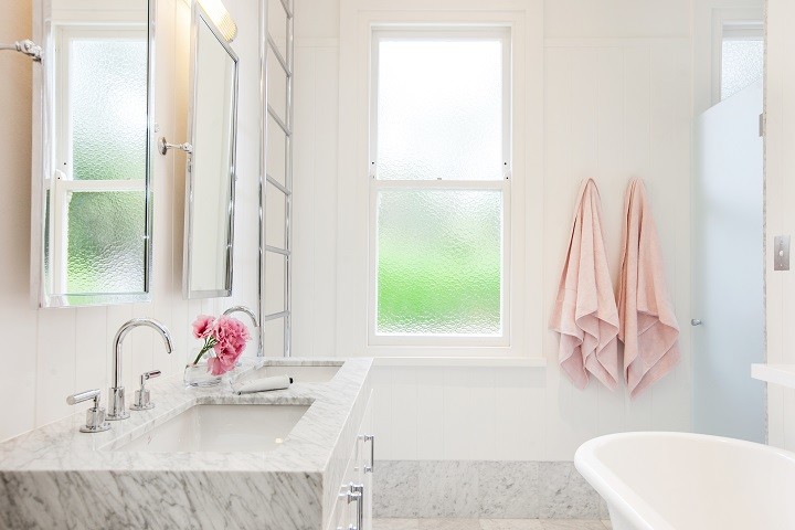 Inspiration for a mid-sized transitional 3/4 bathroom in Sydney with glass-front cabinets, white cabinets, an open shower, a wall-mount toilet, white tile, marble, white walls, marble floors, a pedestal sink, marble benchtops, white floor and an open shower.