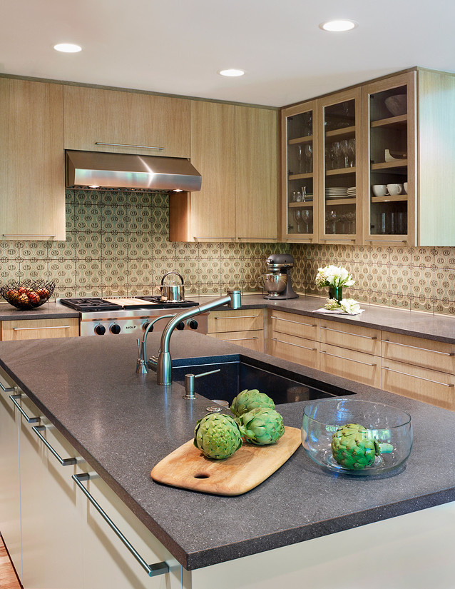 Design ideas for a mid-sized transitional u-shaped kitchen in Chicago with an undermount sink, flat-panel cabinets, light wood cabinets, marble benchtops, green splashback, terra-cotta splashback, stainless steel appliances, light hardwood floors and multiple islands.