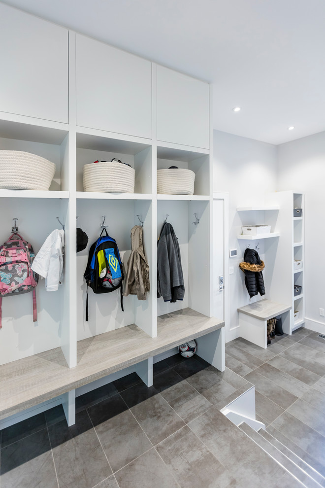 This is an example of a large contemporary mudroom in Toronto with white walls, slate floors, a single front door and a white front door.