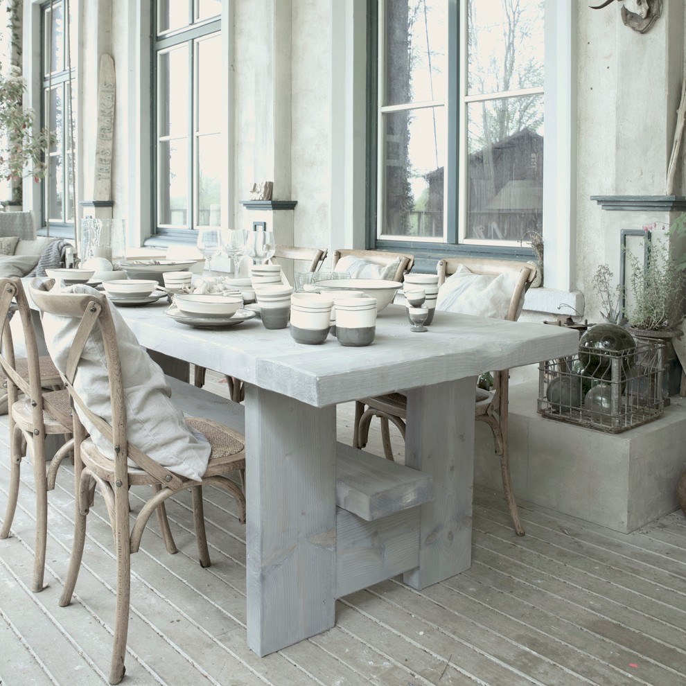 This is an example of a country dining room in Berlin with light hardwood floors.