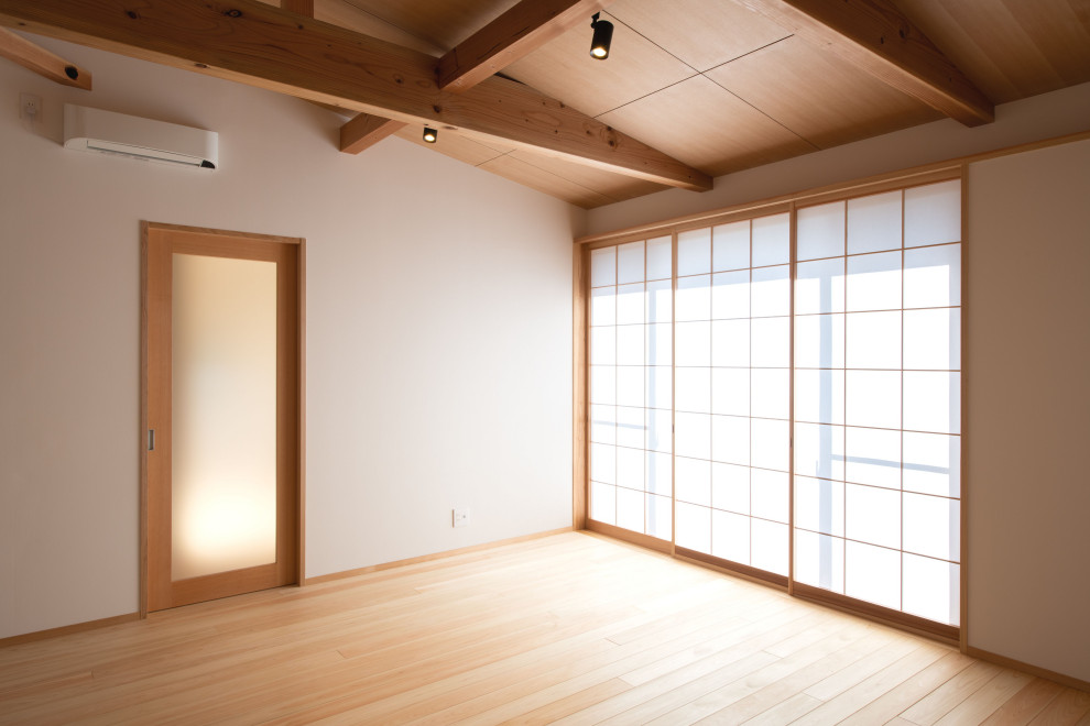 This is an example of a mid-sized asian open concept living room in Nagoya with white walls, medium hardwood floors, no fireplace, a freestanding tv and beige floor.