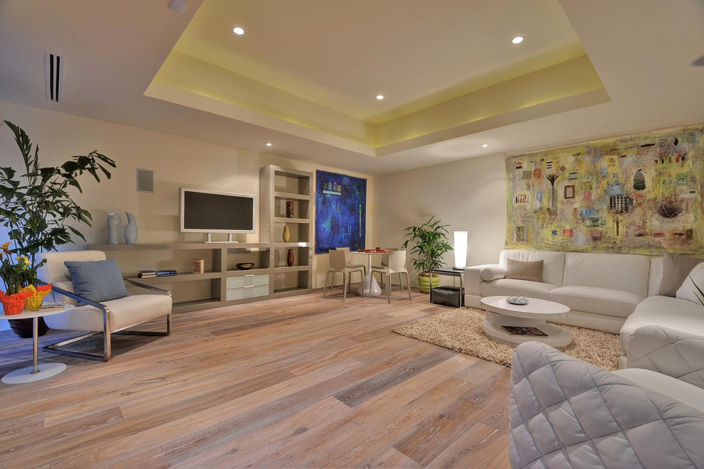 Inspiration for a contemporary open concept family room in New York with beige walls, a freestanding tv and beige floor.